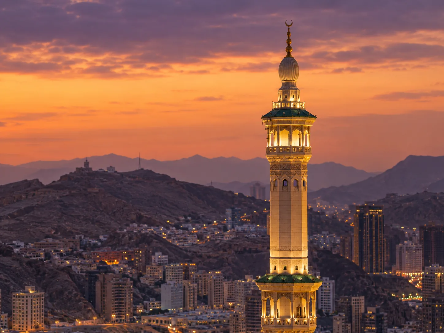 Mescid-i Haram minarelerinden birinin akşam vakti Mekke silueti önündeki görünümü