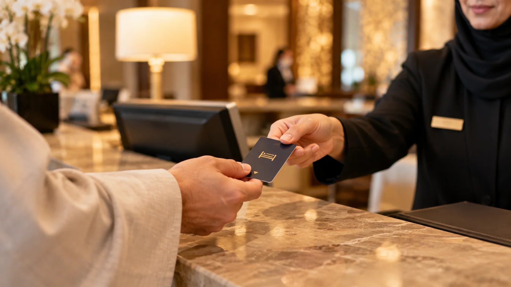 Otel resepsiyonunda anahtar kartını alan yolcunun elleri